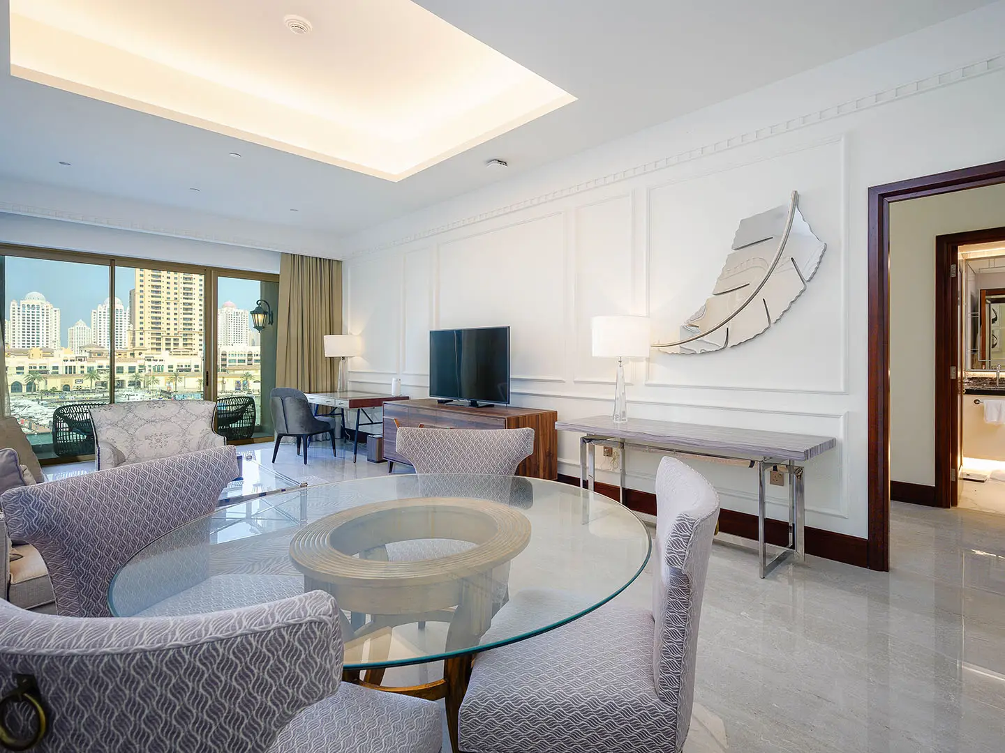 Dining area with glass table and marina view window