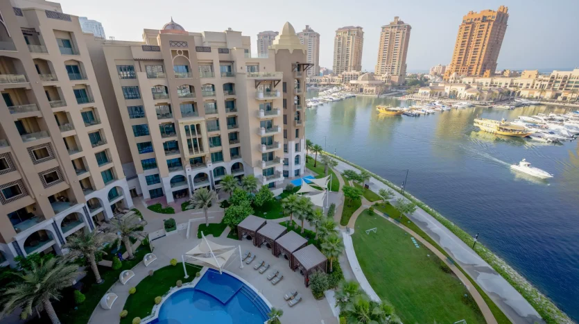 Luxury pool and marina view with garden and buildings